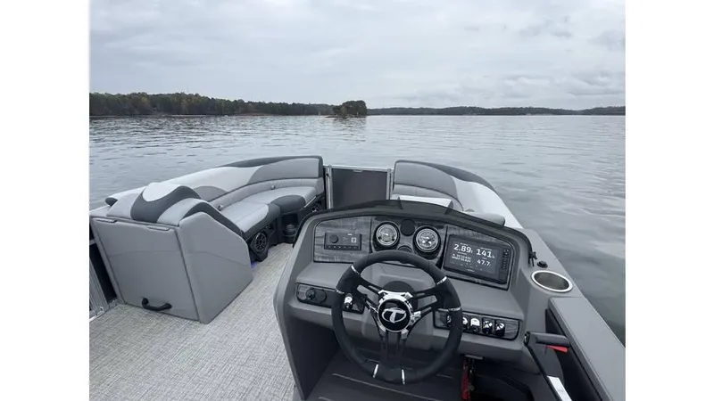 Slide: The Image of 2025 Tahoe Pontoon LTZ Quad Lounger on a serene lake, showcasing modern dashboard and seating. - 5
