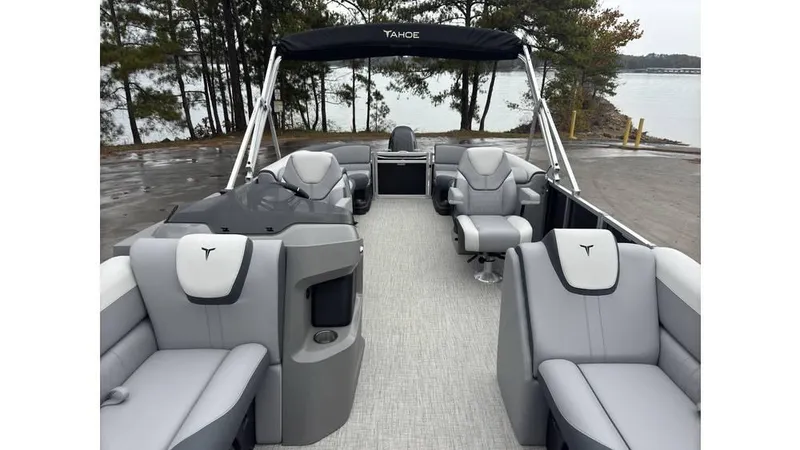 Slide: The Image of 2025 Tahoe Pontoon LTZ Quad Lounger with sleek gray seating and canopy, docked by a lake. - 6
