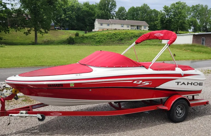 Slide: The Image of Red and white 2013 Tahoe Q5i boat on trailer, parked outdoors. - 13