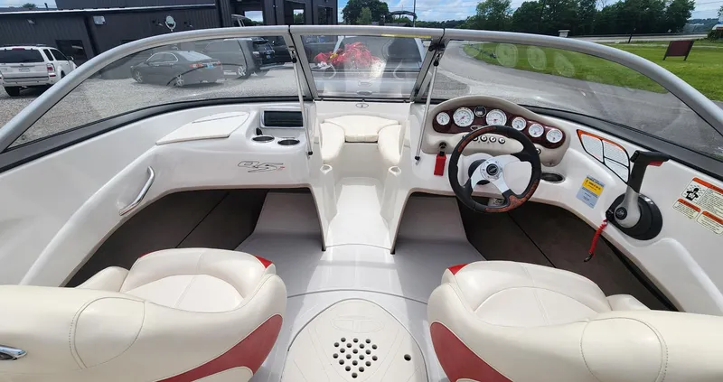 Slide: The Image of 2013 Tahoe Q5i boat interior with white and red seating, dashboard, and steering wheel. - 7