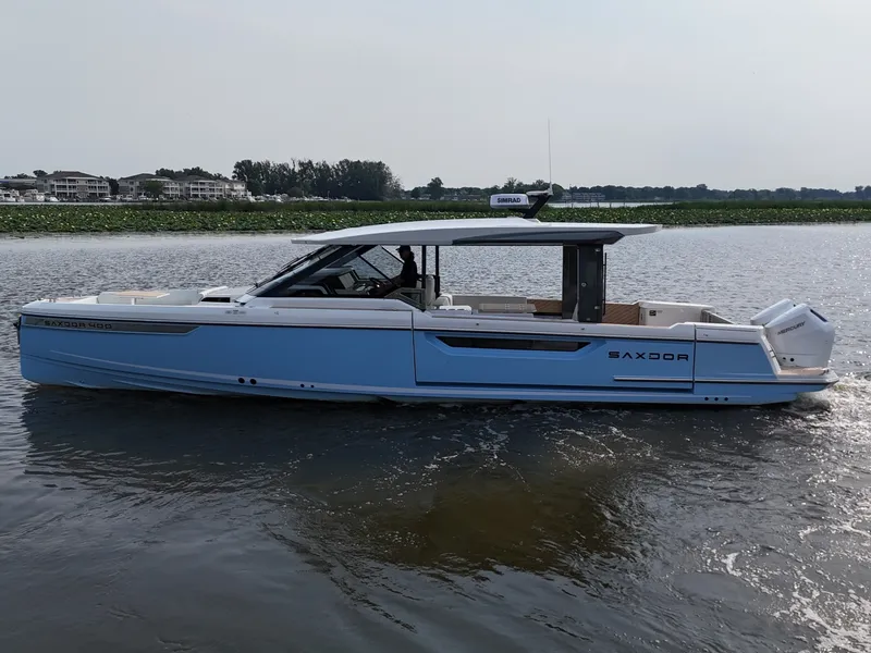 Slide: The Image of 2026 Saxdor 400 GTO on calm water, featuring sleek design and spacious deck. - 2