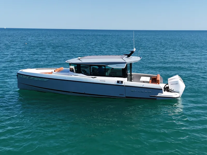 Slide: The Image of A modern Saxdor 320 GTC boat on calm water with a sleek, white hull. - 2