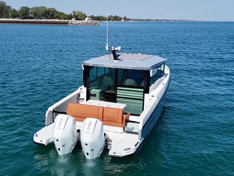 Slide: The Image of The image shows a 2026 Saxdor 320 GTC boat on calm water with two outboard engines. - 1