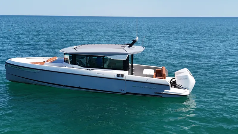 Slide: The Image of A 2026 Saxdor 320 GTC on calm waters. It features a modern design with an outboard motor. - 5
