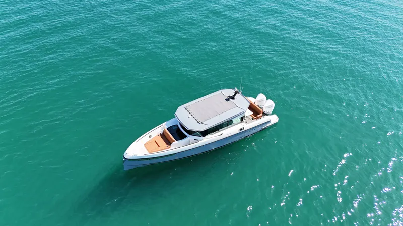 Slide: The Image of A 2026 Saxdor 320 GTC cruising on calm, turquoise waters. The boat features a sleek, modern design. - 7