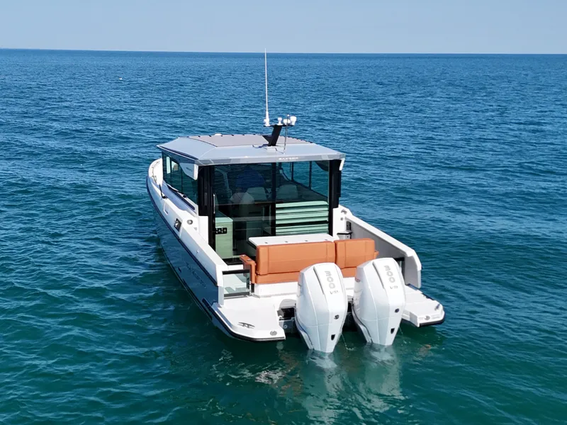 Slide: The Image of A 2026 Saxdor 320 GTC on calm water with twin outboard engines and a sleek design. - 3