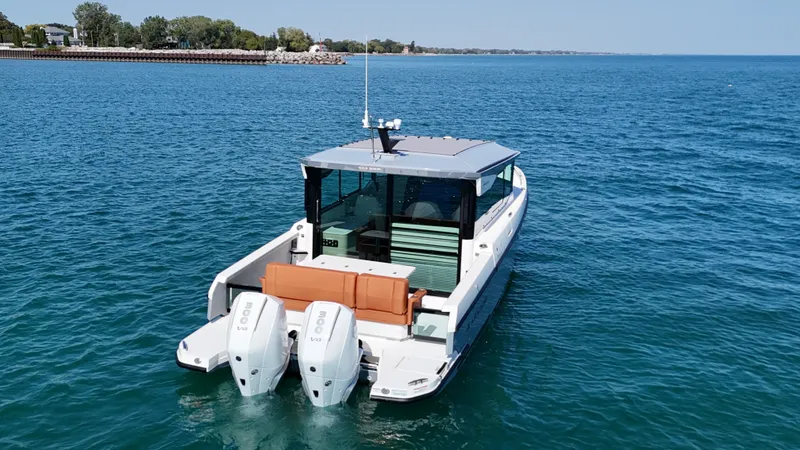 Slide: The Image of A 2026 Saxdor 320 GTC cruising on calm waters. It features twin outboard engines and a modern design. - 4