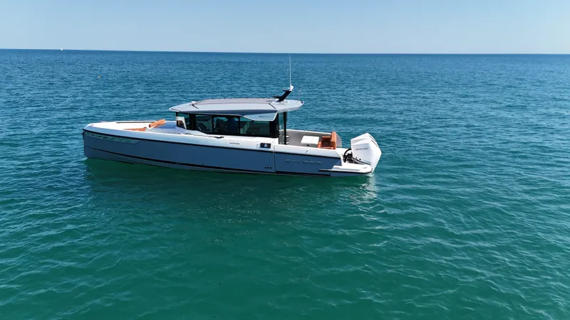 Slide: The Image of A modern motorboat, Saxdor 320 GTC, floats on calm blue water under a clear sky. - 6