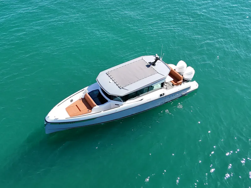 Slide: The Image of A 2026 Saxdor 320 GTC on calm, turquoise water. The boat features a sleek, modern design. - 4