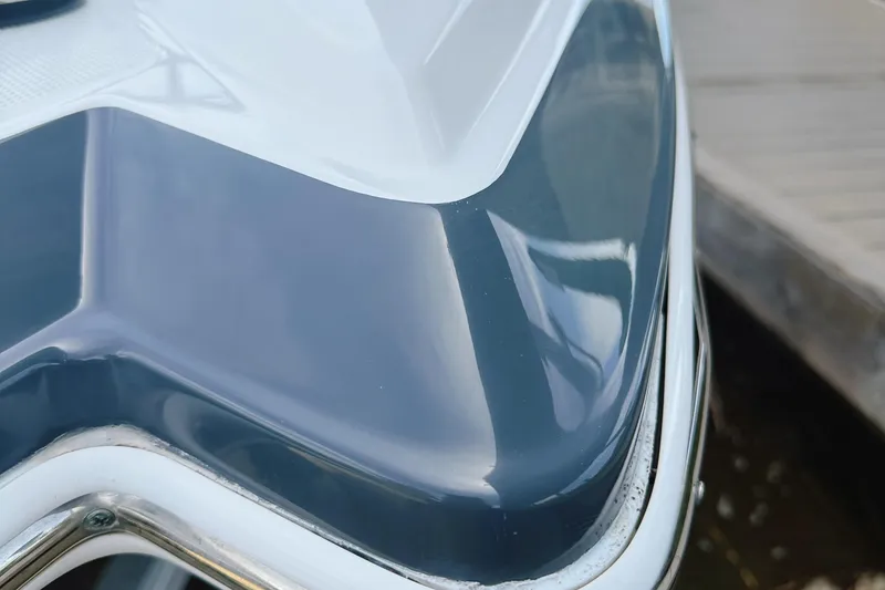 Slide: The Image of Close-up of 2015 Chaparral 244 Sunesta boat's sleek, glossy hull near dock. - 16