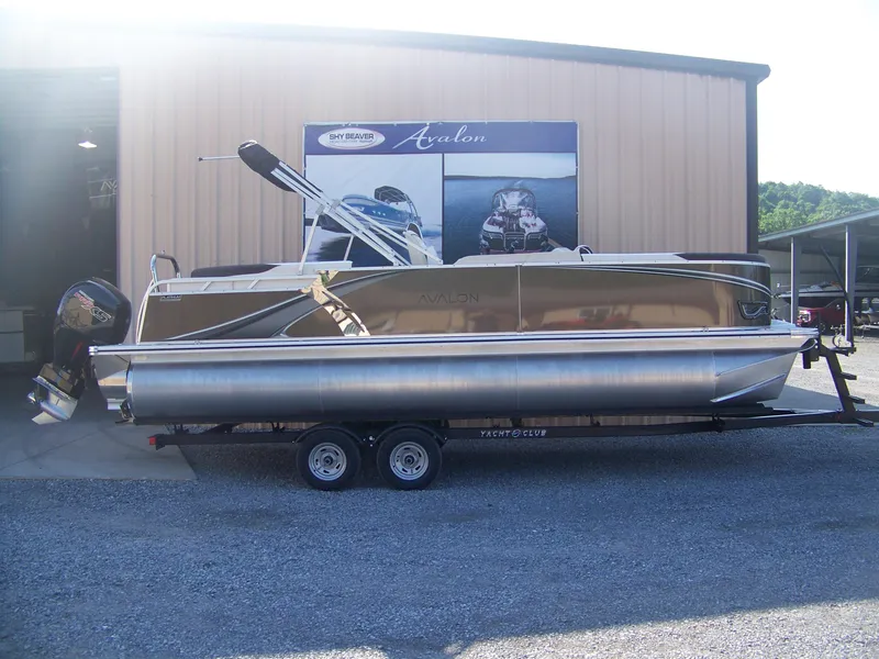 The Image of 2025 Avalon LSZ ELITE pontoon boat on trailer outside a showroom. - 1