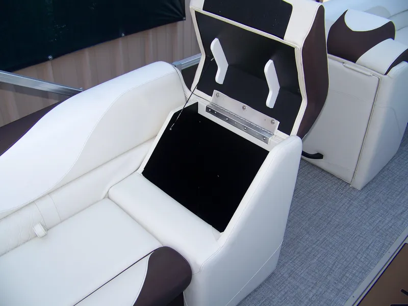 Slide: The Image of 2025 Avalon LSZ ELITE boat seat with open storage compartment, featuring white and brown upholstery. - 12