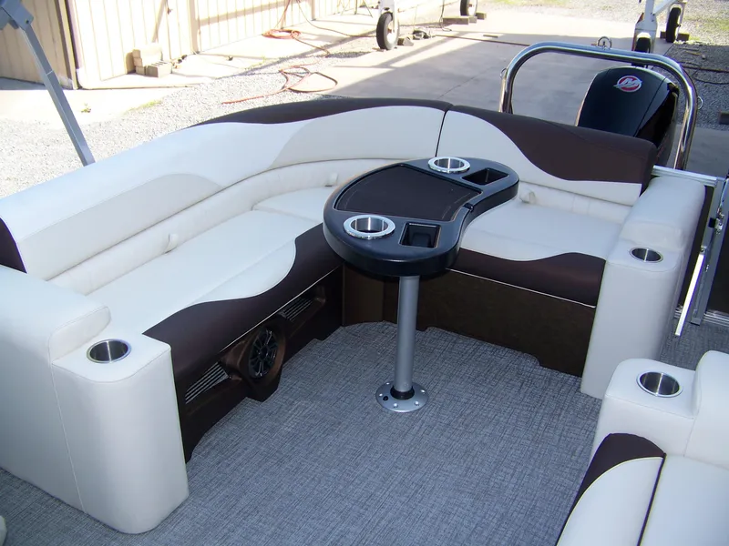 Slide: The Image of Luxurious seating area on 2025 Avalon LSZ ELITE pontoon boat with table and cup holders. - 7