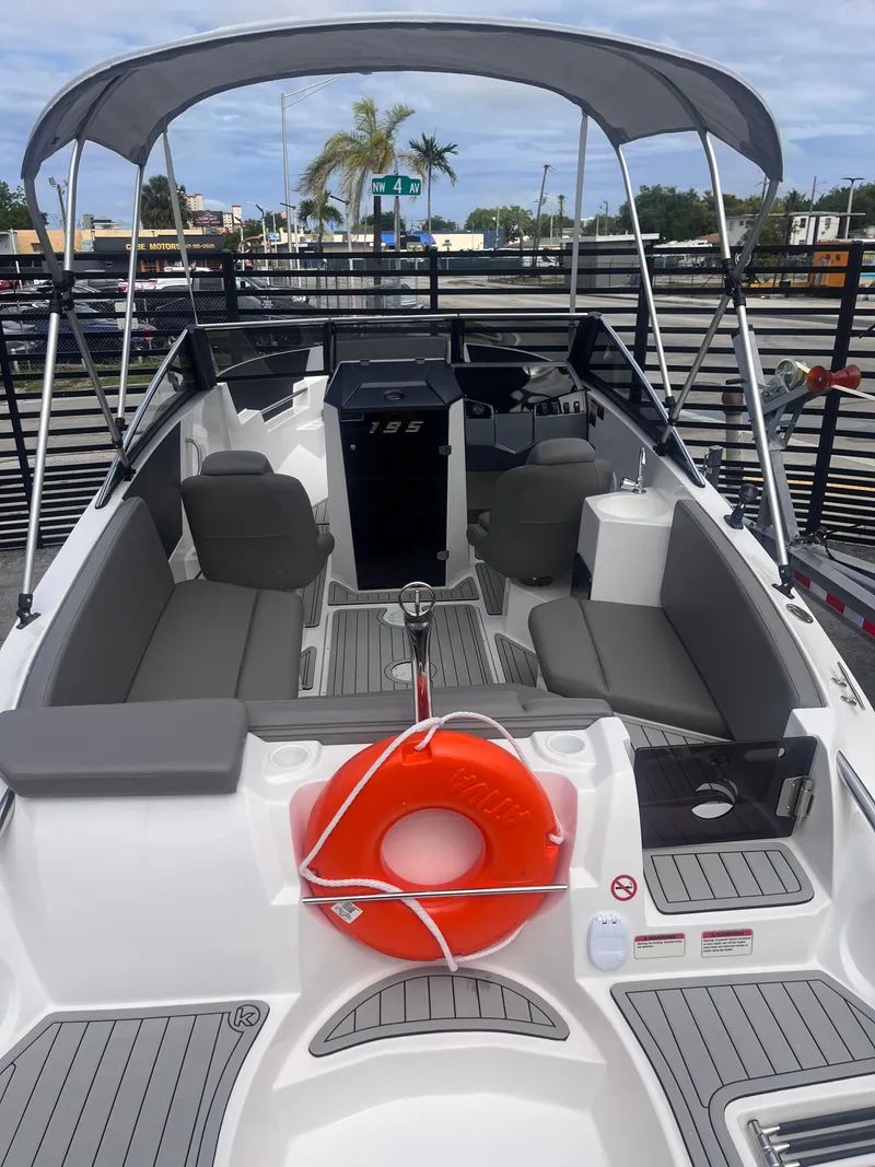Slide: The Image of 2025 Ventura Crossover boat with gray seating, canopy, and orange life preserver on deck. - 3