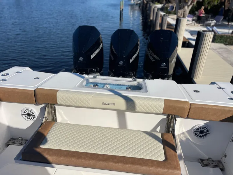Slide: The Image of 2022 Caymas 341 CC boat with triple Mercury engines docked by the water. - 11