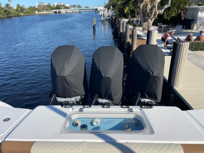 Slide: The Image of 2022 Caymas 341 CC boat with covered engines docked by a scenic waterfront. - 12