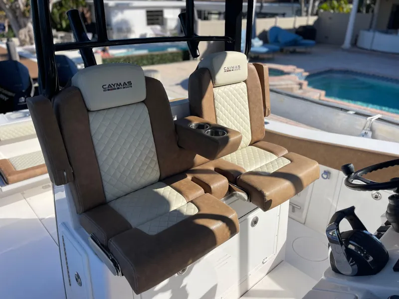 Slide: The Image of Luxurious seating on 2022 Caymas 341 CC boat, featuring brown and cream upholstery near a pool. - 27