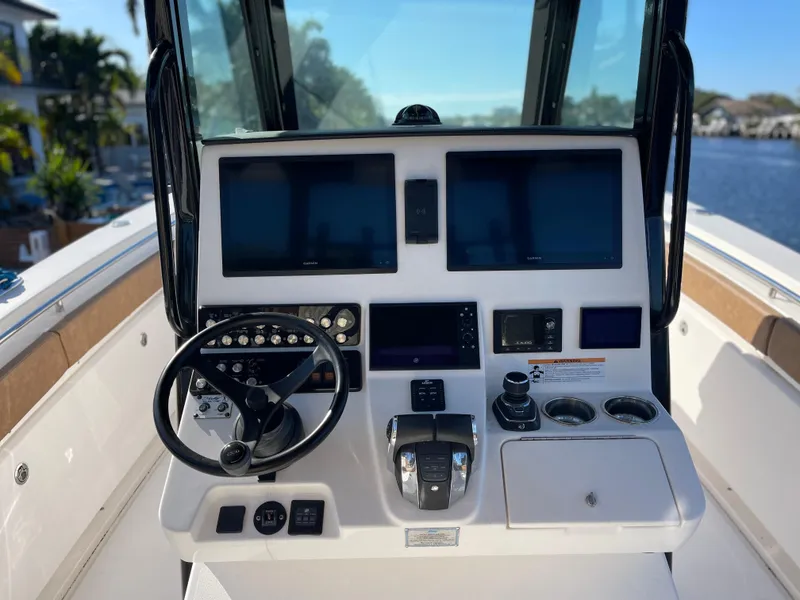 Slide: The Image of 2022 Caymas 341 CC boat dashboard with dual screens and steering wheel. - 28