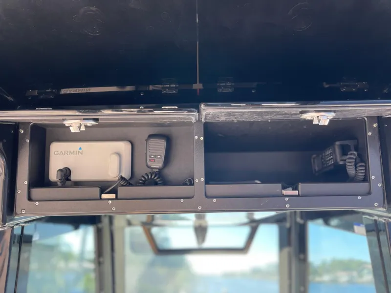 Slide: The Image of 2022 Caymas 341 CC boat storage compartments with Garmin equipment and communication devices. - 37
