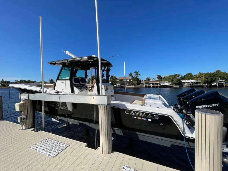 Slide: The Image of 2022 Caymas 341 CC boat docked, featuring sleek design and Mercury engines under clear blue sky. - 4