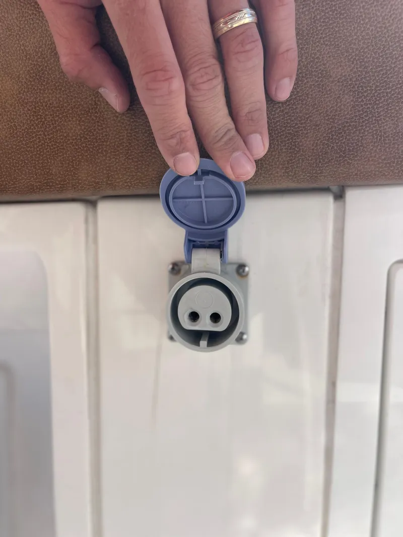 Slide: The Image of 2022 Caymas 341 CC boat power socket with hand opening blue cover. - 41