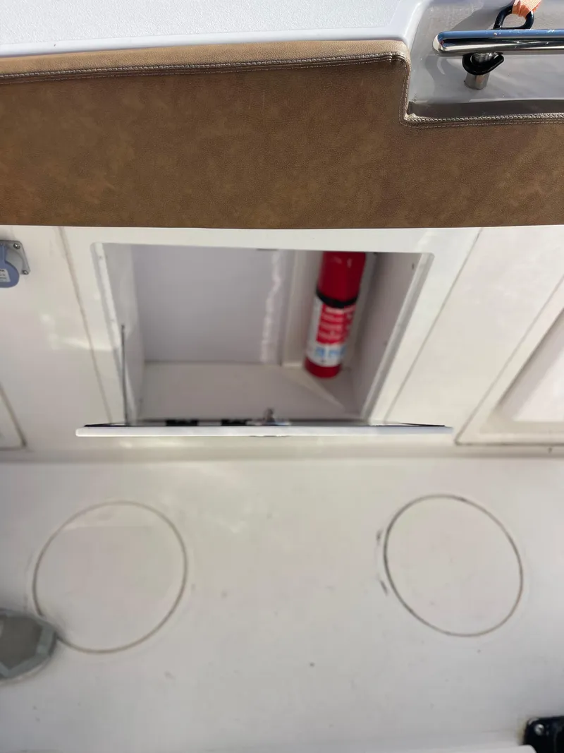 Slide: The Image of 2022 Caymas 341 CC boat storage compartment with fire extinguisher. - 48