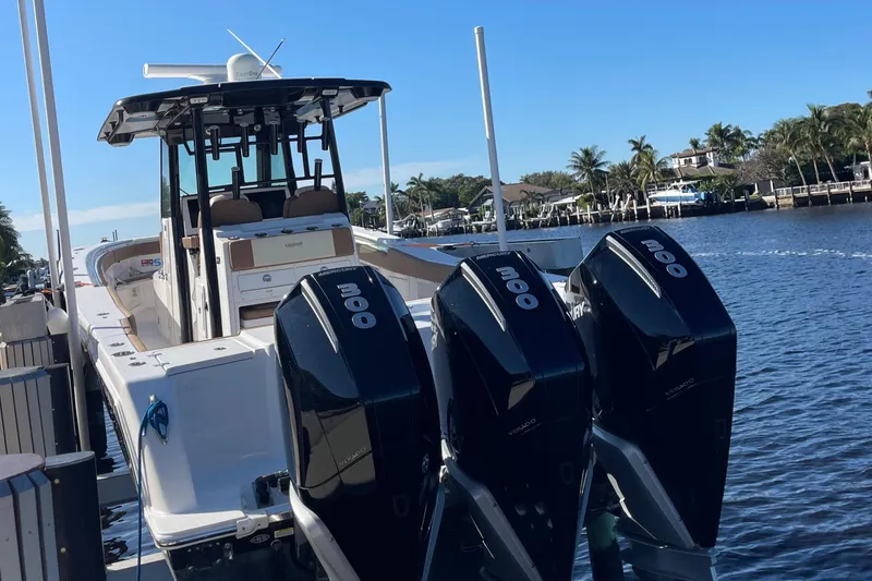 Slide: The Image of 2022 Caymas 341 CC boat docked with triple outboard engines. - 8