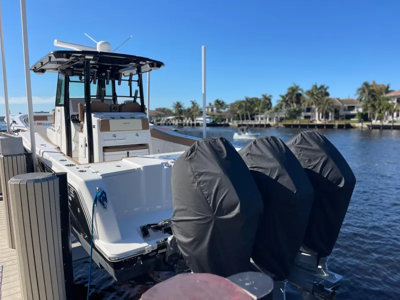 Slide: The Image of 2022 Caymas 341 CC boat docked with triple engines, scenic waterfront view. - 9