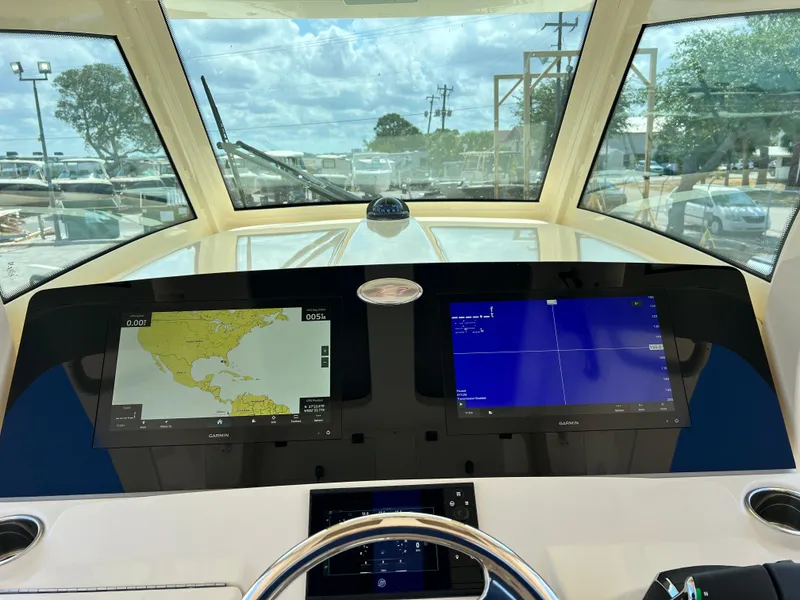 Slide: The Image of 2025 Scout 357 LXF boat dashboard with dual navigation screens and steering wheel. - 11