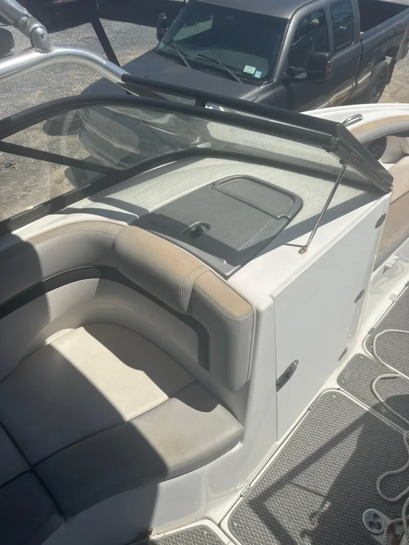 Slide: The Image of 2010 Yamaha Boats 212SS interior with seating and dashboard, parked near a black truck. - 15