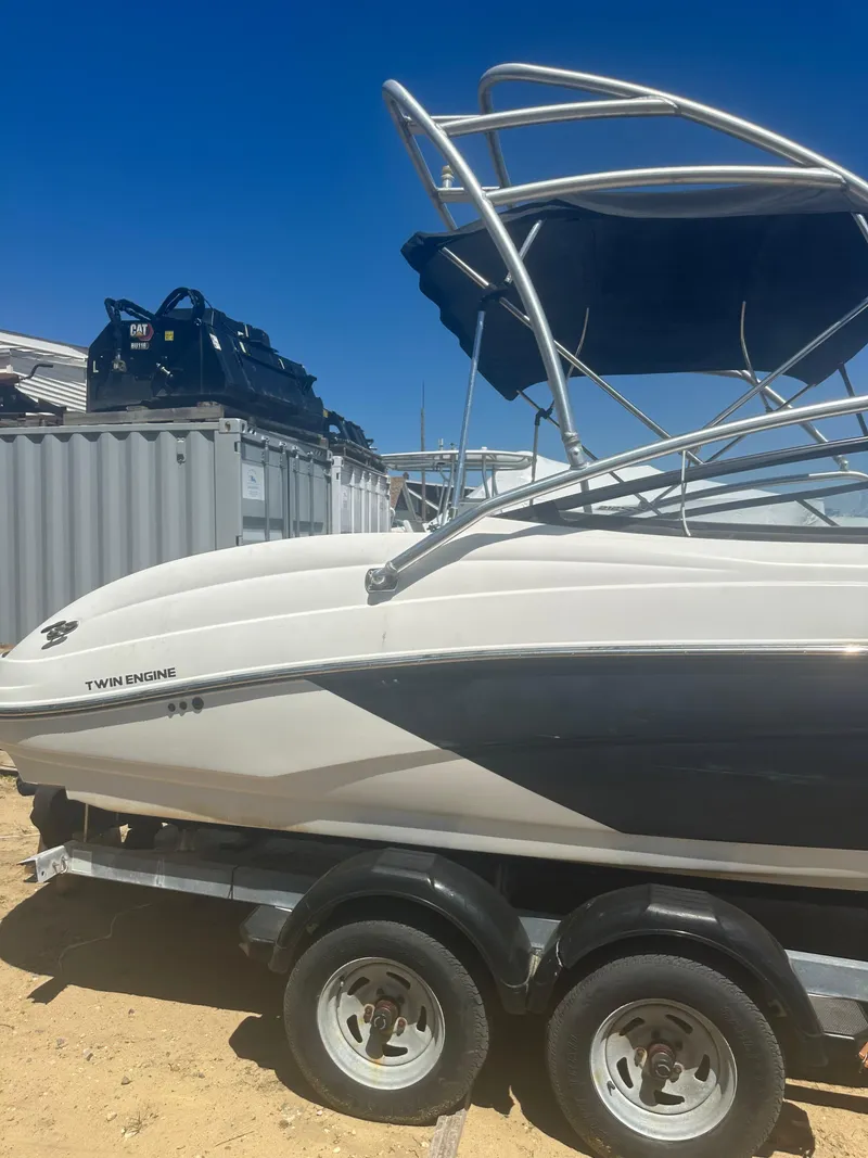 Slide: The Image of 2010 Yamaha Boats 212SS on trailer, featuring sleek design and twin engines under clear blue sky. - 2