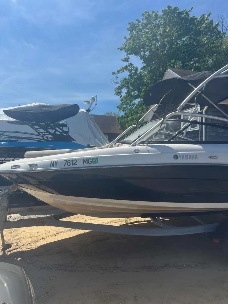 Slide: The Image of 2010 Yamaha Boats 212SS on trailer, parked outdoors under clear blue sky. - 5