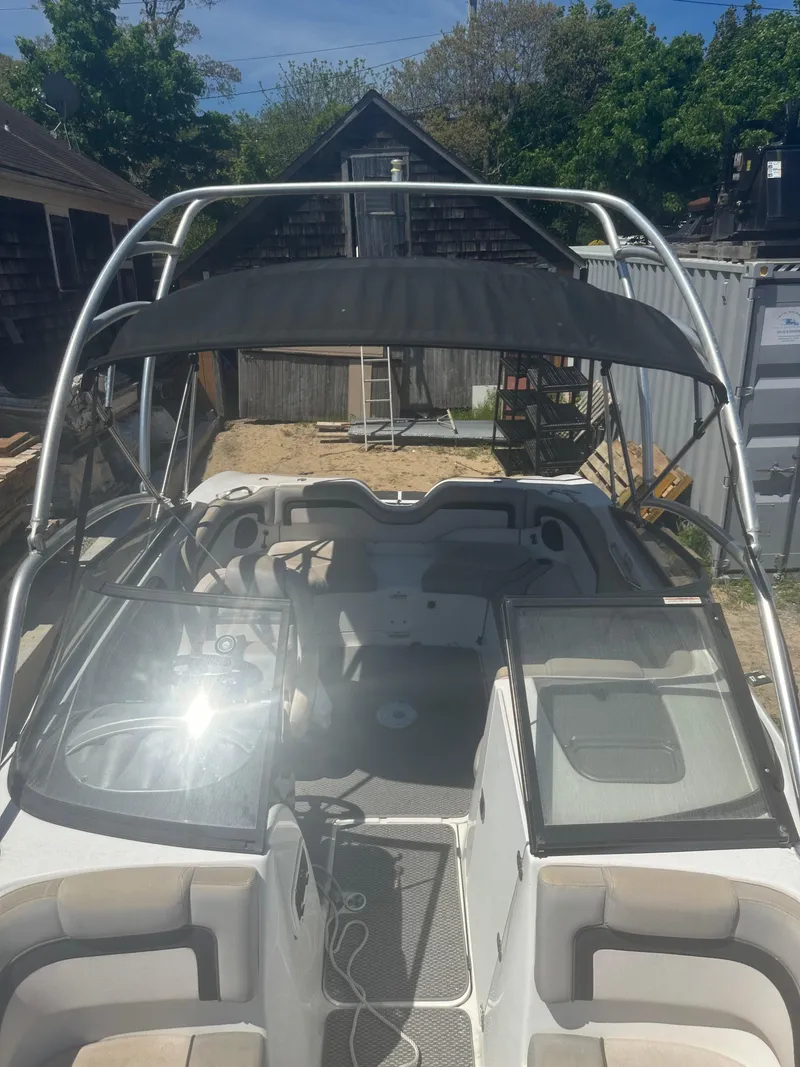 Slide: The Image of 2010 Yamaha Boats 212SS with canopy, docked outdoors, surrounded by trees and structures. - 9