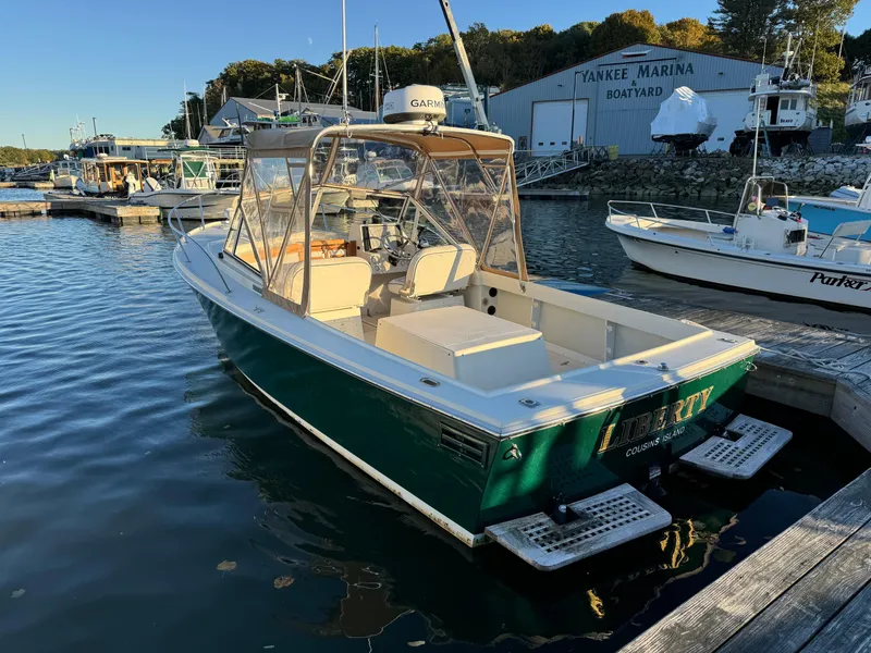 Slide: The Image of 2004 Limestone 24 Cuddy boat docked at marina, clear sky, calm water. - 14