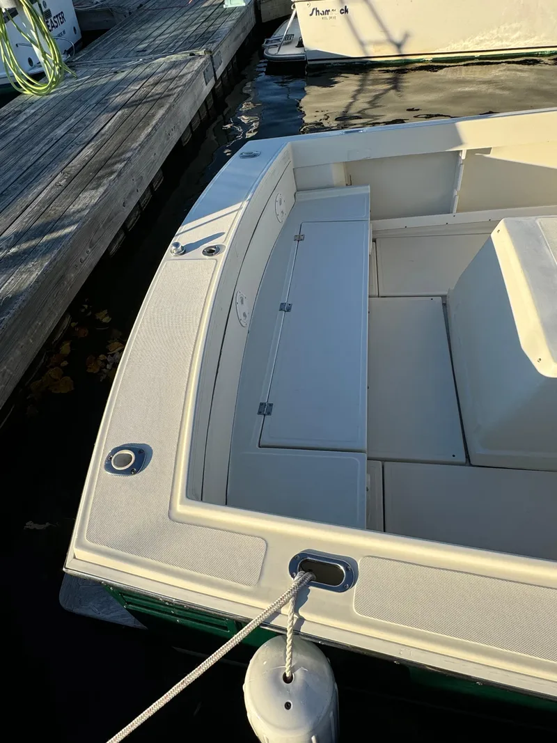 Slide: The Image of 2004 Limestone 24 Cuddy boat docked, featuring spacious seating and clean design. - 23