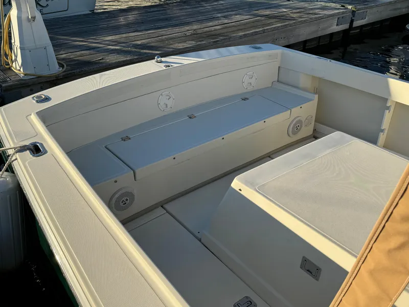 Slide: The Image of 2004 Limestone 24 Cuddy boat interior with seating and storage, docked by wooden pier. - 25