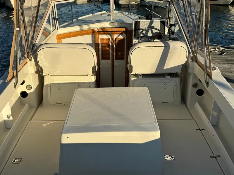 Slide: The Image of 2004 Limestone 24 Cuddy boat interior with seating and steering wheel. - 29