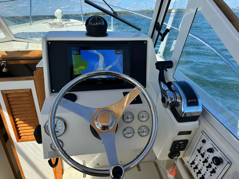 Slide: The Image of 2004 Limestone 24 Cuddy boat dashboard with steering wheel and navigation system. - 31