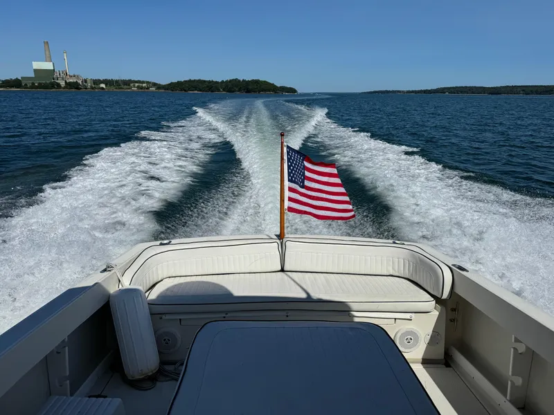 Slide: The Image of 2004 Limestone 24 Cuddy cruising on open water with American flag. - 33
