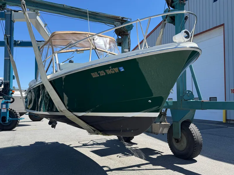 Slide: The Image of 2004 Limestone 24 Cuddy boat on lift, green hull, marina setting. - 7