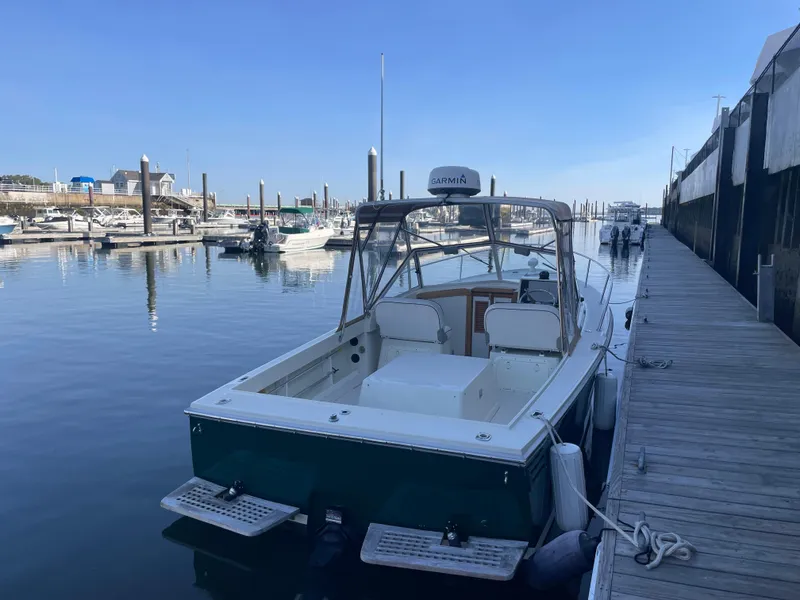 Slide: The Image of 2004 Limestone 24 Cuddy boat docked at a marina on a clear day. - 9