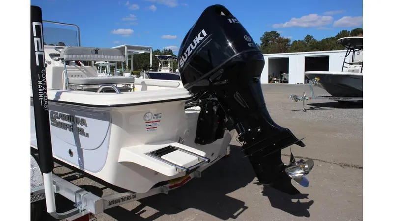 Slide: The Image of 2025 Carolina Skiff 19 LS boat with Suzuki outboard motor, parked outdoors. - 13
