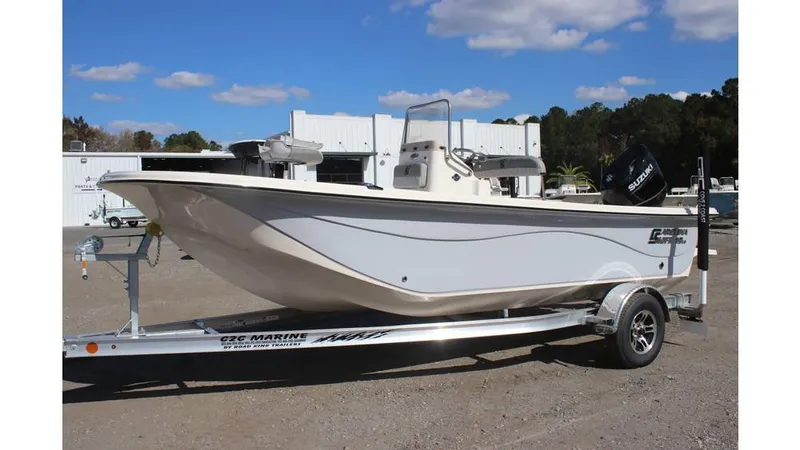 Slide: The Image of 2025 Carolina Skiff 19 LS boat on trailer, parked outdoors under blue sky. - 15
