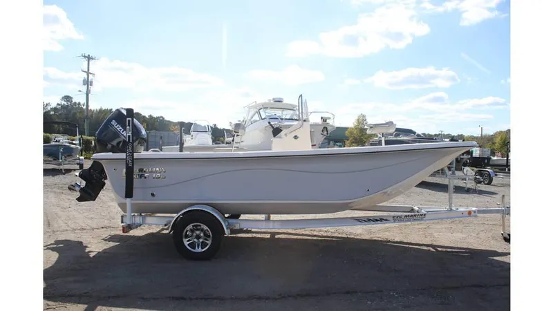 Slide: The Image of 2025 Carolina Skiff 19 LS boat on trailer, parked outdoors under a clear sky. - 16