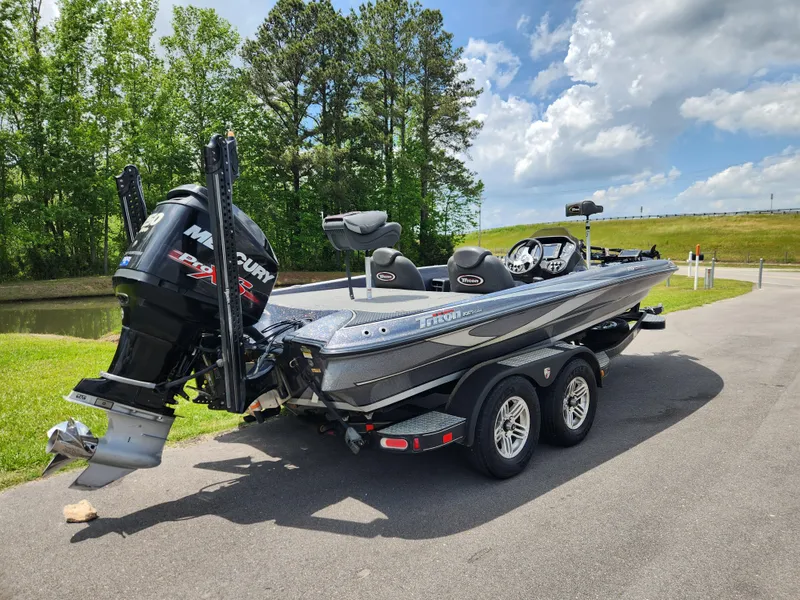 Slide: The Image of 2018 Triton 20 TRX boat with Mercury engine on a trailer, parked near a lake. - 2