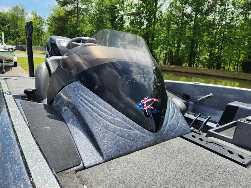 Slide: The Image of 2018 Triton 20 TRX boat with sleek design, parked outdoors on a sunny day. - 7