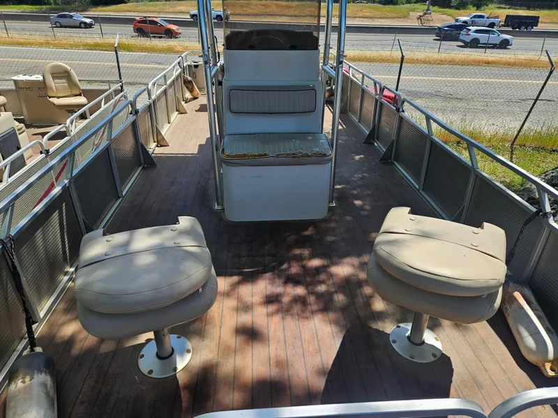 Slide: The Image of 2019 Apex Marine ANGERQWEST pontoon boat with seating, parked near a highway. - 10