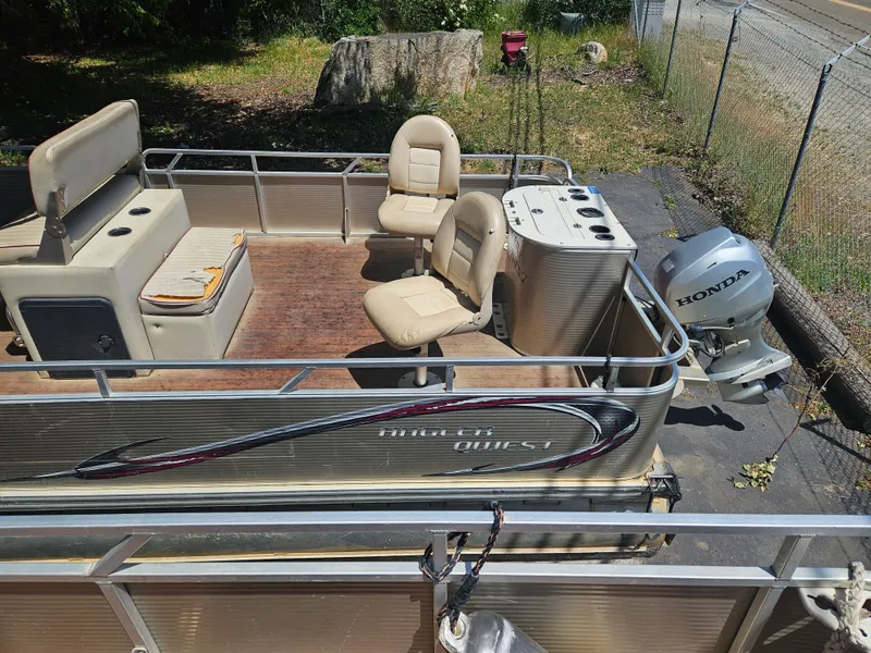 Slide: The Image of 2019 Apex Marine ANGERQWEST pontoon boat with Honda motor, beige seating, and wooden deck. - 5