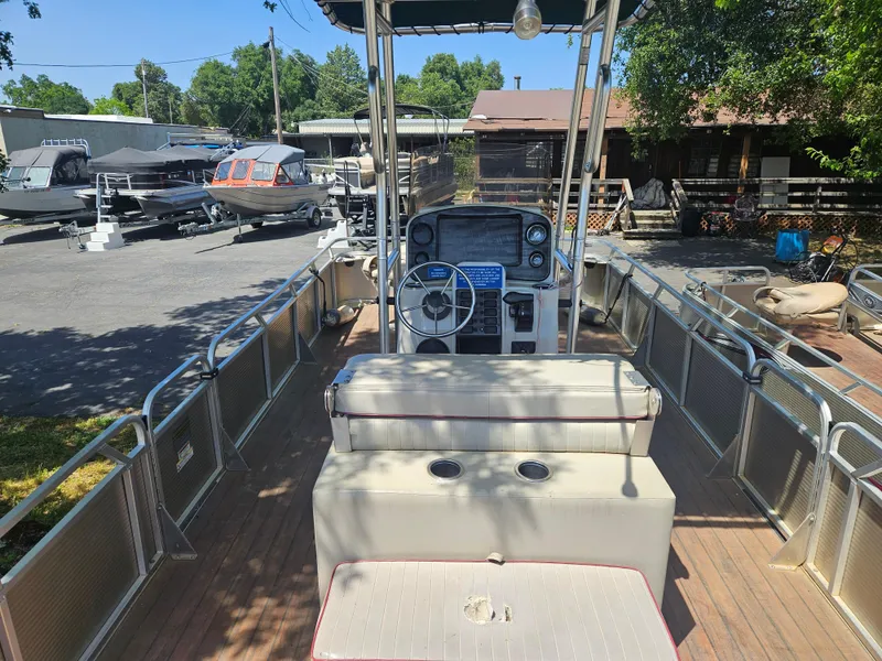 Slide: The Image of 2019 Apex Marine ANGERQWEST pontoon boat with steering console, docked outdoors. - 6