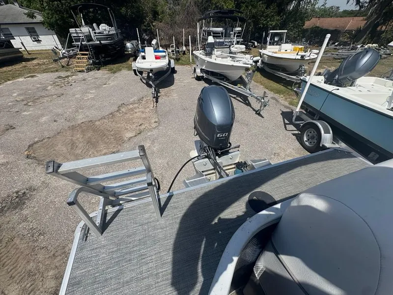Slide: The Image of Sweetwater 1880 CX pontoon boat, 2021 model, with outboard motor in a boatyard setting. - 3